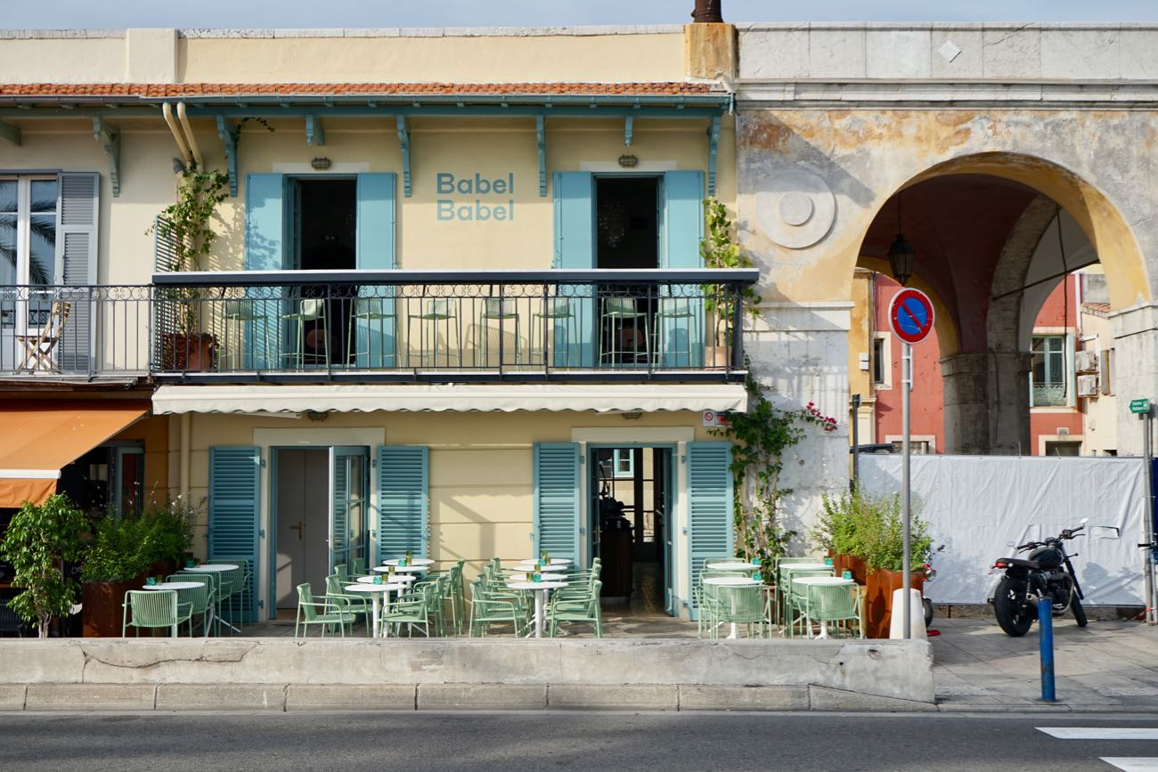 Trendy Levantine bar and restaurant Babel Babel – Sunset views on the Promenade des Anglais Colorful exterior of Babel Babel restaurant with terrace seating overlooking the sea