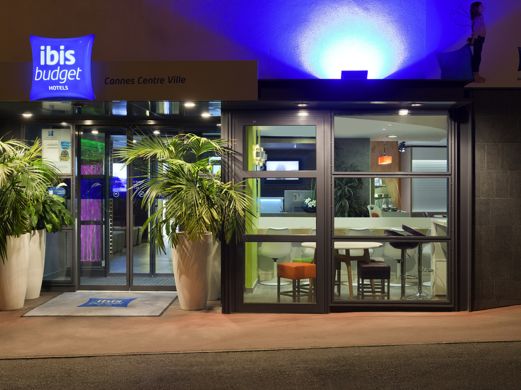 Ibis Budget Cannes – Modern and clean budget hotel near attractions Modern entrance of Ibis Budget hotel in downtown Cannes lit at night