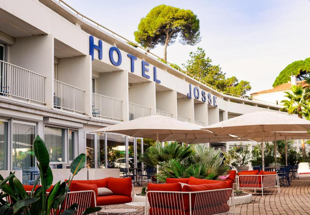 Hôtel Josse – Seaside Hotel with Spacious Rooms in Antibes Modern facade of Hôtel Josse with terrace and umbrellas facing the sea
