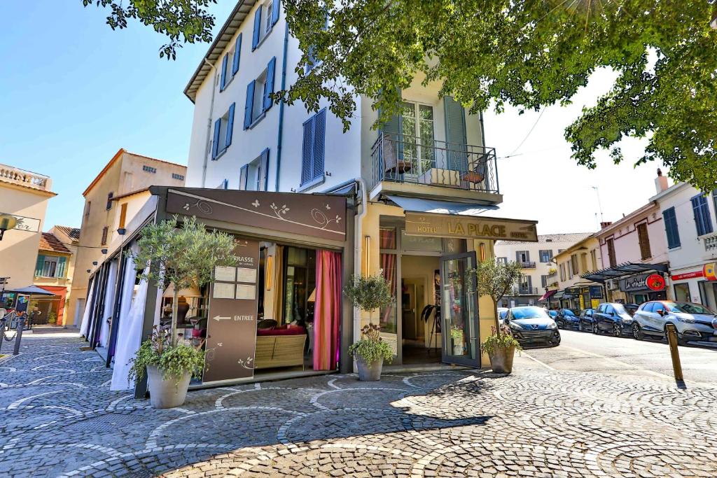 Hotel La Place – Boutique Stay in the Heart of Antibes Old Town Street view of Hotel La Place with elegant facade and nearby restaurants