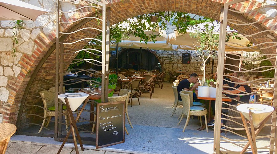 L’Altro - Trendy Italian Trattoria in Antibes Outdoor terrace at L’Altro trattoria with brick arches and casual seating in Antibes