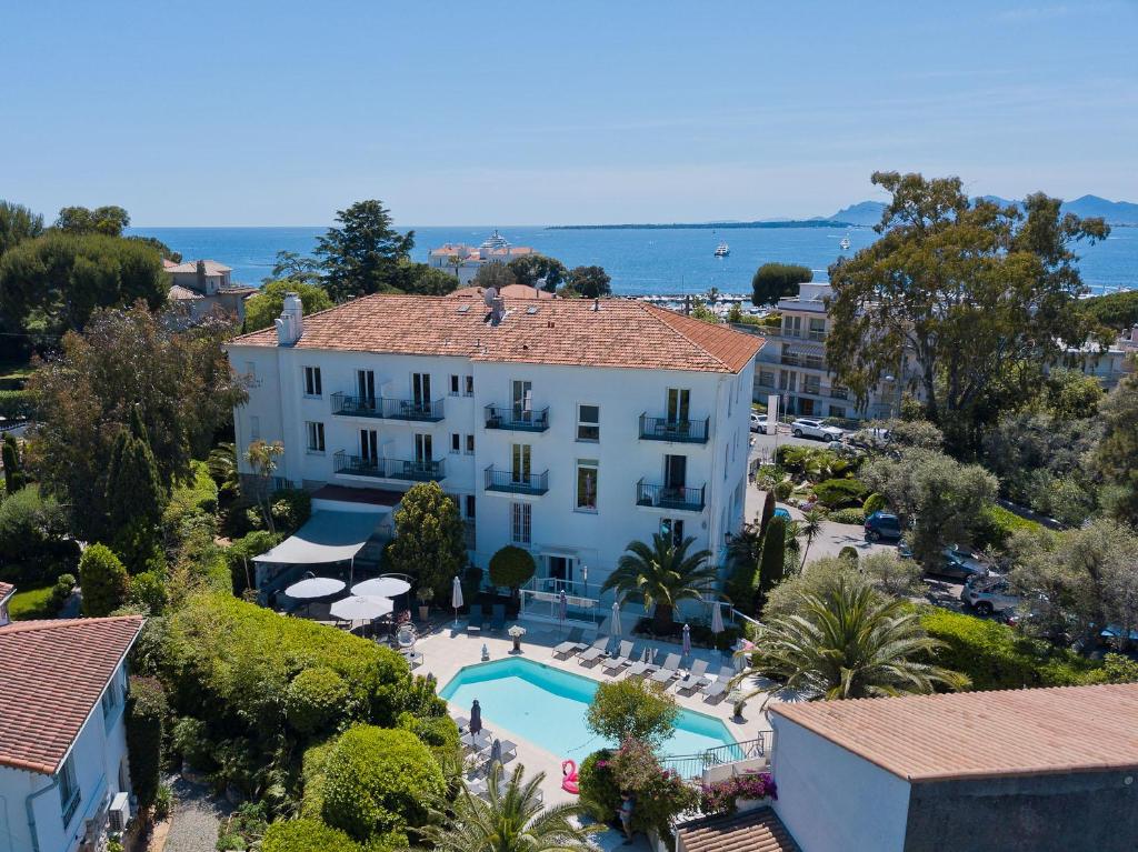 La Villa Hotel – Boutique Stay in Antibes with Pool, Gardens, and Sea Views Aerial view of La Villa Hotel in Antibes with outdoor pool, lush gardens, and sea in the background