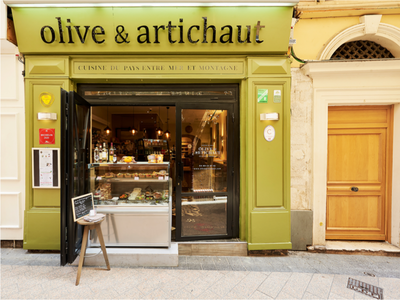Farm-to-table Mediterranean cuisine at Olive & Artichaut – A foodie favorite in Nice Front of Olive & Artichaut restaurant with green facade and market-style display