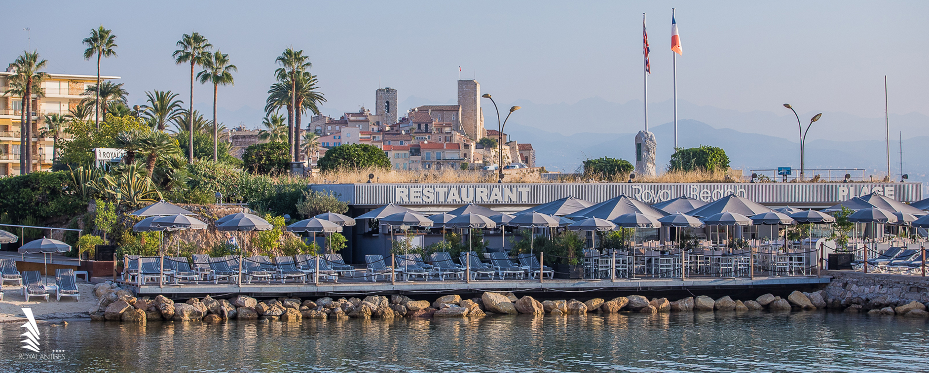 Royal Antibes – Modern 4-Star Hotel with Beach Club Access Beachfront view of Royal Antibes Hotel with sun loungers and umbrellas facing the Mediterranean