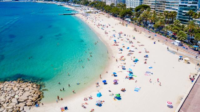 Cannes public beach with turquoise water and umbrellas