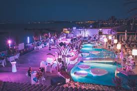 Dance and chill under the stars at La Siesta Beach Club in Antibes Seaside beach club at night with glowing pools and lounge seating