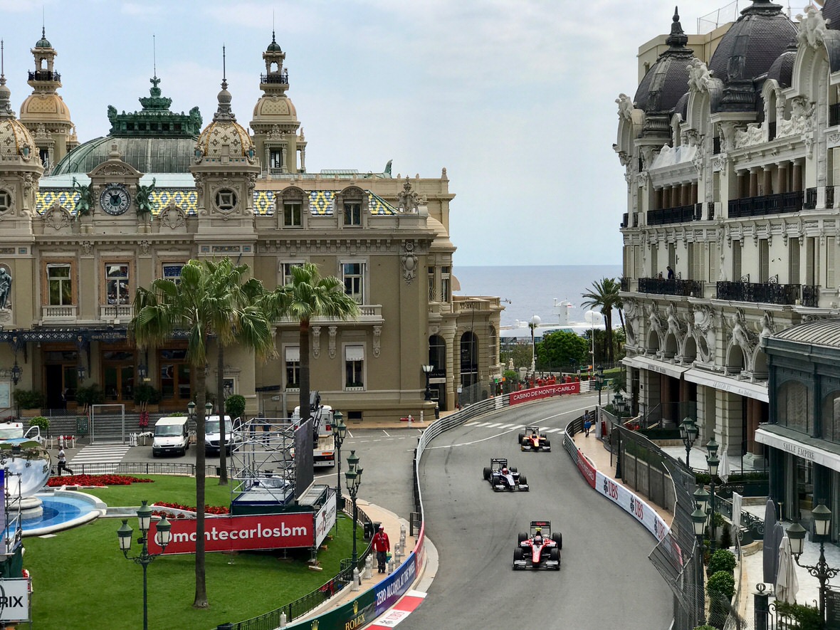 Thrilling high-speed race in Monaco Formula 1 cars racing past the Monte Carlo Casino