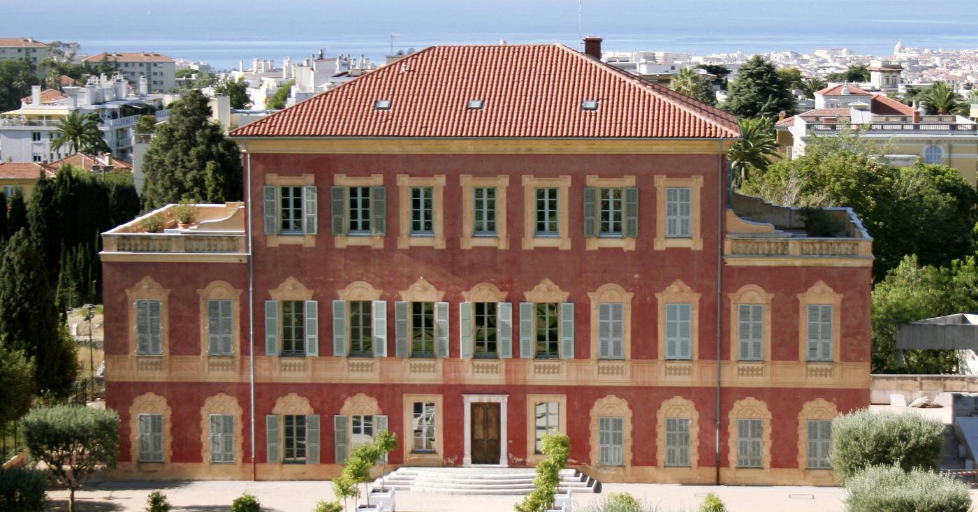 Red-toned villa housing the Musée Matisse, surrounded by greenery in Cimiez, Nice